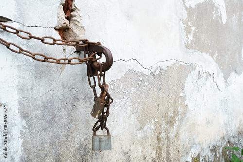 Rusty Chains and Multiple Padlocks on a Cracked Concrete Wall