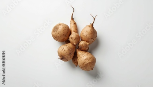 Fresh yam tubers displayed from above in a group on a white surface, highlighting raw vegetables for cooking