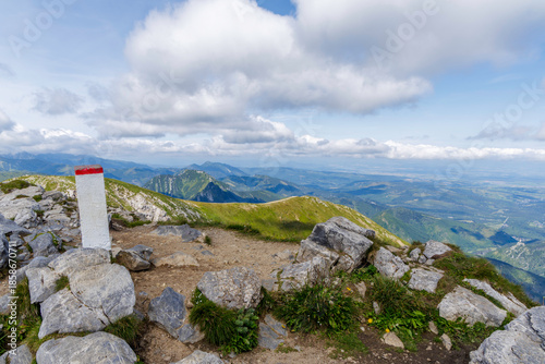 Mountain Border Marker on Rocky Ridge Overlooking Green Valley