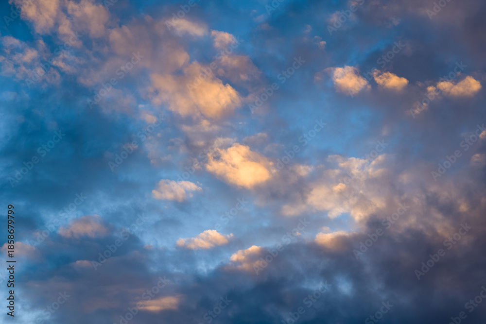 Fototapeta premium Soft golden hues illuminate scattered clouds against a blue sky above the Adriatic Sea. The scene highlights subtle gradients and natural textures in a peaceful, open skyscape.