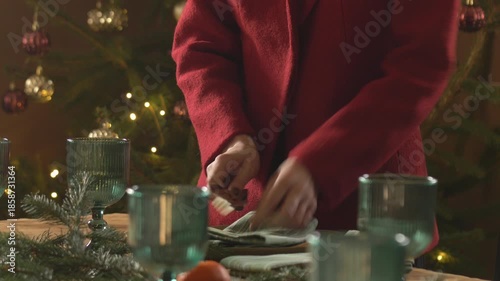 woman prepares the table for a festive Christmas dinner with the whole family at home