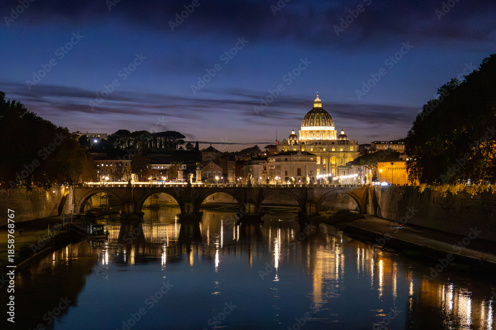 Obraz premium View of St. Peter's Basilica in Vatican City and the Sant'Angelo Bridge and the Tiber River, from the Umberto I Bridge, at dusk in Rome, Italy.