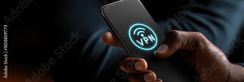 Smartphone Displaying VPN Icon in a Dark Environment With a Hand Holding the Device, Showcasing Digital Privacy