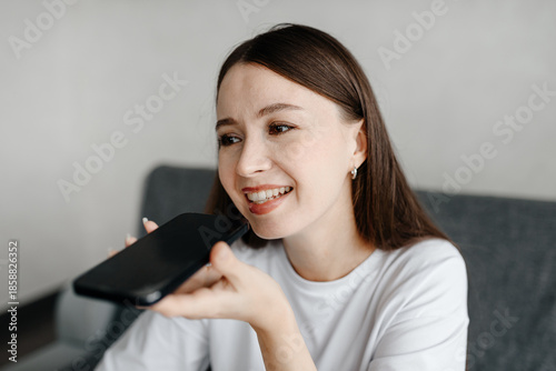 Tableau sur toile young beautiful caucasian brunette woman recording voice message, smiling widely