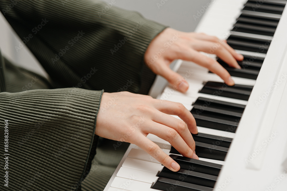 Obraz premium female pianist hands on black and white synthesizer keyboard, close-up view, young woman playing piano, professional musician