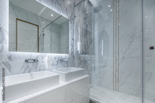 Fotografia A bathroom with marble walls and bright lights