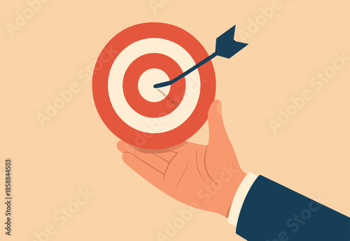 Goal or target, focus and concentration to achieve success, purpose or objective, aiming at target bullseye, accuracy, challenge and aspiration, businessman hand hold target with arrow hit bullseye.