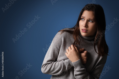 Scared young woman on dark ...