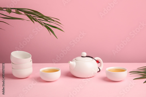 Teapot with cups of tea and...