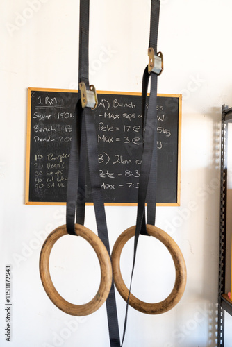 two fitness rings hanging with a chalkboard in the background tracking personal best fitness statistics