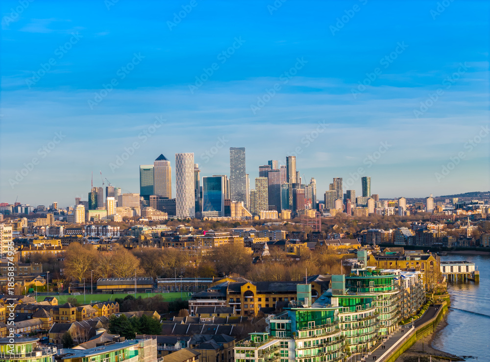 Obraz premium Canary Wharf skyline in the distance - modern London financial district panorama with skyscrapers. Aerial drone view angle from Tower Bridge side