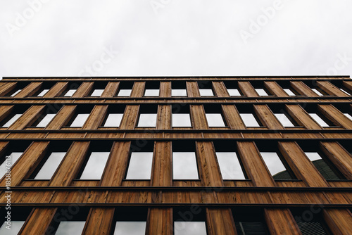 Modern Wooden Office Building Facade With Repeating Windows and Overcast Sky