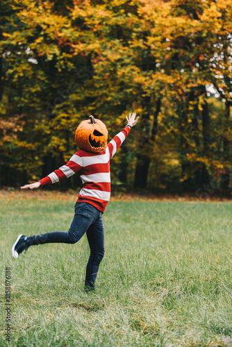 Playful Person with Pumpkin Head Dancing in Autumn Field