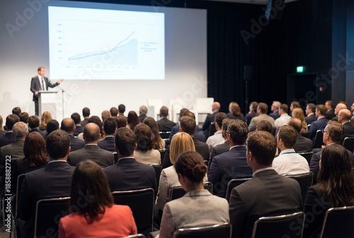 Rear view of audience listening to speaker at a business conference