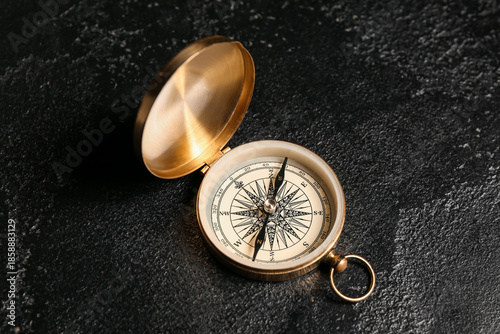 Golden compass on black gru...