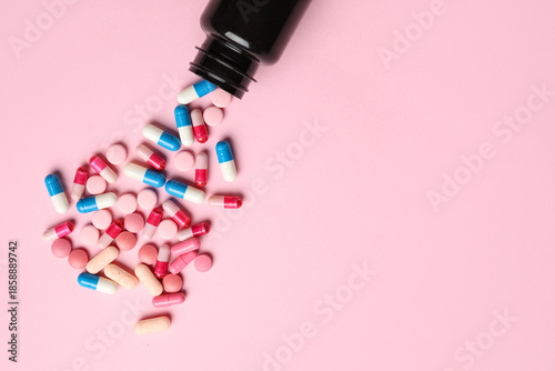 Bottle with pills on pink b...