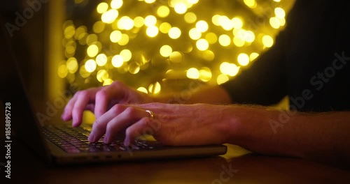 Wallpaper Mural Man Typing on Laptop Keyboard in Dark Room with Warm Glow Bokeh in Background Torontodigital.ca