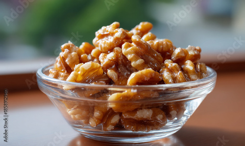 Fresh glossy walnuts in clear glass bowl under natural light. generative aI