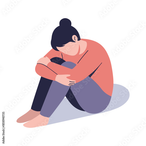 A person is sitting alone, curled up in a ball, with their head down.