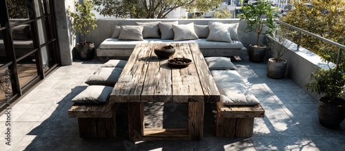 Outdoor patio with rustic wooden table, benches, and a cushioned lounge