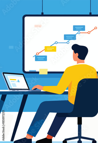 Person at desk working on laptop with chart on whiteboard