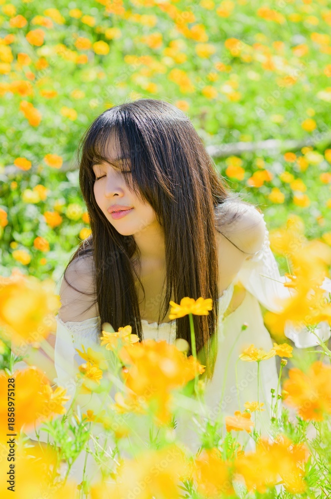 Naklejka premium Beautiful Woman Enjoying Spring in a Vibrant Field of Flowers