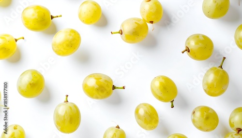 Overhead view of scattered green grapes with stems, against a clean white background