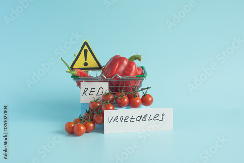 Red vegetables and fruits, sweet and hot peppers, grapes and cherry tomatoes in close-up on a light background and the inscription 