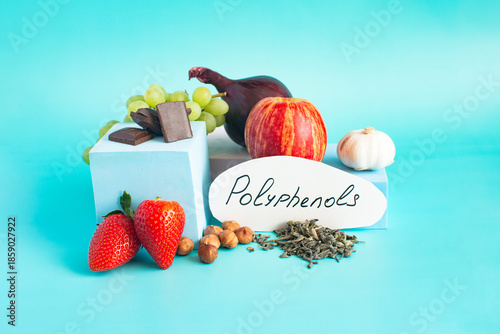 Products containing useful polyphenols in their composition. Grapes, onions, garlic, chocolate and other products in close-up on a light background and the inscription on paper 