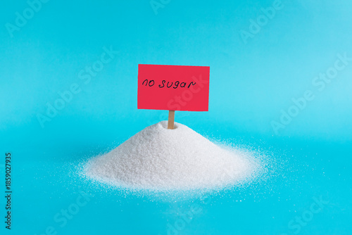 A large mountain of granulated sugar and a bright red sign stuck in it with the inscription 