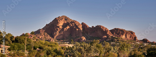 Desert mountain above treelined neighborhood at golden hour