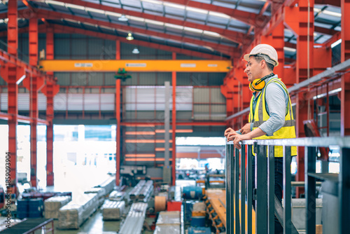 Fotografi Caucasian industrial engineer men wear safety helmet vest standing on elevated catwalk supervising factory floor