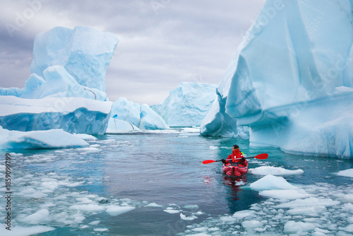 Foto kayaking in Antarctica, man paddling on kayak between icebergs and ice, adventur