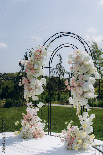 Outdoor wedding ceremony arch decorated with fresh flowers