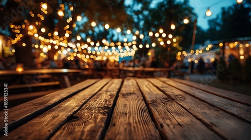 Wooden table foreground, background shows bokeh of fairy lights and blurred people at outdoor event
