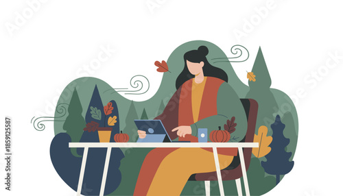 Freelance woman using a tablet outdoors in the windy autumn forest Digital nomad lifestyle