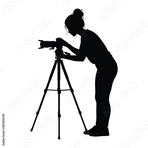 Female photographer adjusting camera on tripod silhouette