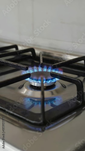 Close-up of a modern kitchen gas stove with a bright blue flame burning steadily, symbolizing household energy, cooking, and natural gas usage