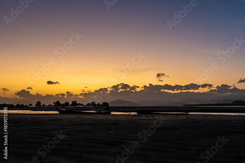 Silhouette of Traditional Longtail Boats at Low Tide After Sunset