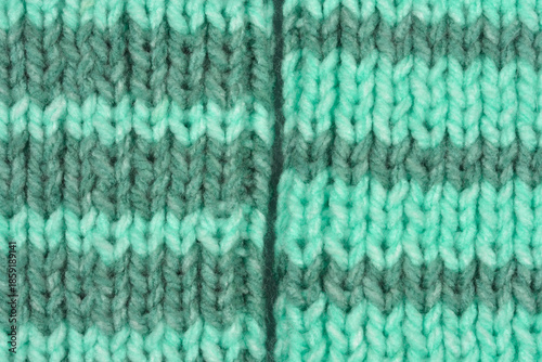 Close up of two knitted wool socks with mint green and grey stripes