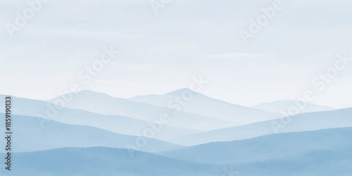 A breathtaking morning view of misty mountains and clouds blankets the forest valley as a golden sunrise illuminates the snowy horizon under a blue sky