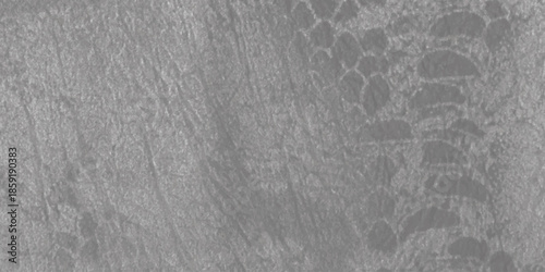 A detailed close-up of a dual-textured surface featuring a delicate lace pattern over a rough grey material