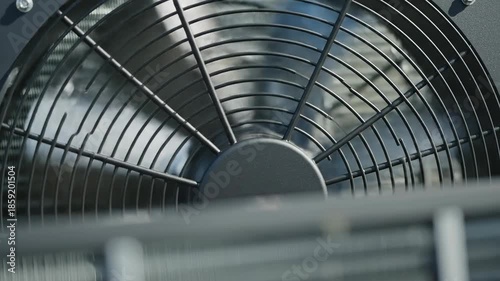 Extreme close-up slow motion shot of a modern air source heat pump condenser fan spinning rapidly for residential climate control sustainable, appliance, engineering