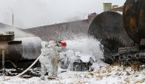 Tableau sur toile Firefighters spray foam on a large tank after a train derailment in snowy condit