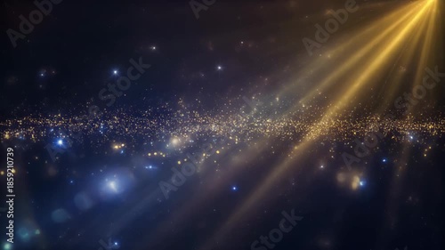 Sparkling light rays shining through gold and blue particles on dark background