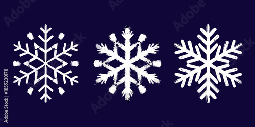Three unique white snowflakes presented against a dark navy blue backdrop