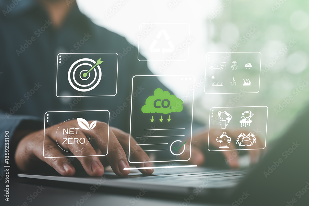 © Nirusmee - Close-up of person using a laptop with net zero and carbon reduction icons, symbolizing CO₂ reduction, recycling, green energy, and sustainable digital innovation.