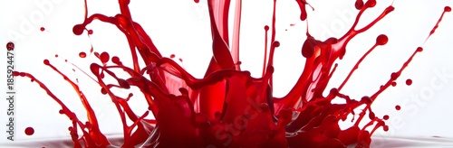Bright red liquid splashes dynamically in mid-air against a white background for dramatic effect