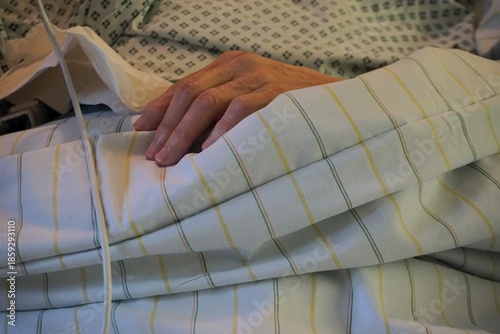 Alte kranke pflegebedürftige Frau liegt nach Operation in Krankenbett auf Intensivstation in Krankenhaus 