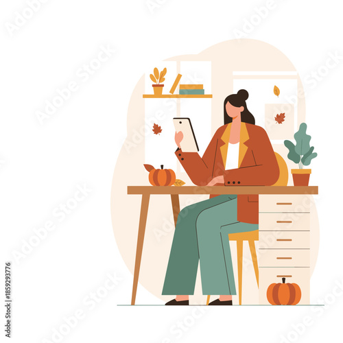 Professional woman using a digital tablet at her desk in a cozy pumpkindecorated autumn home office